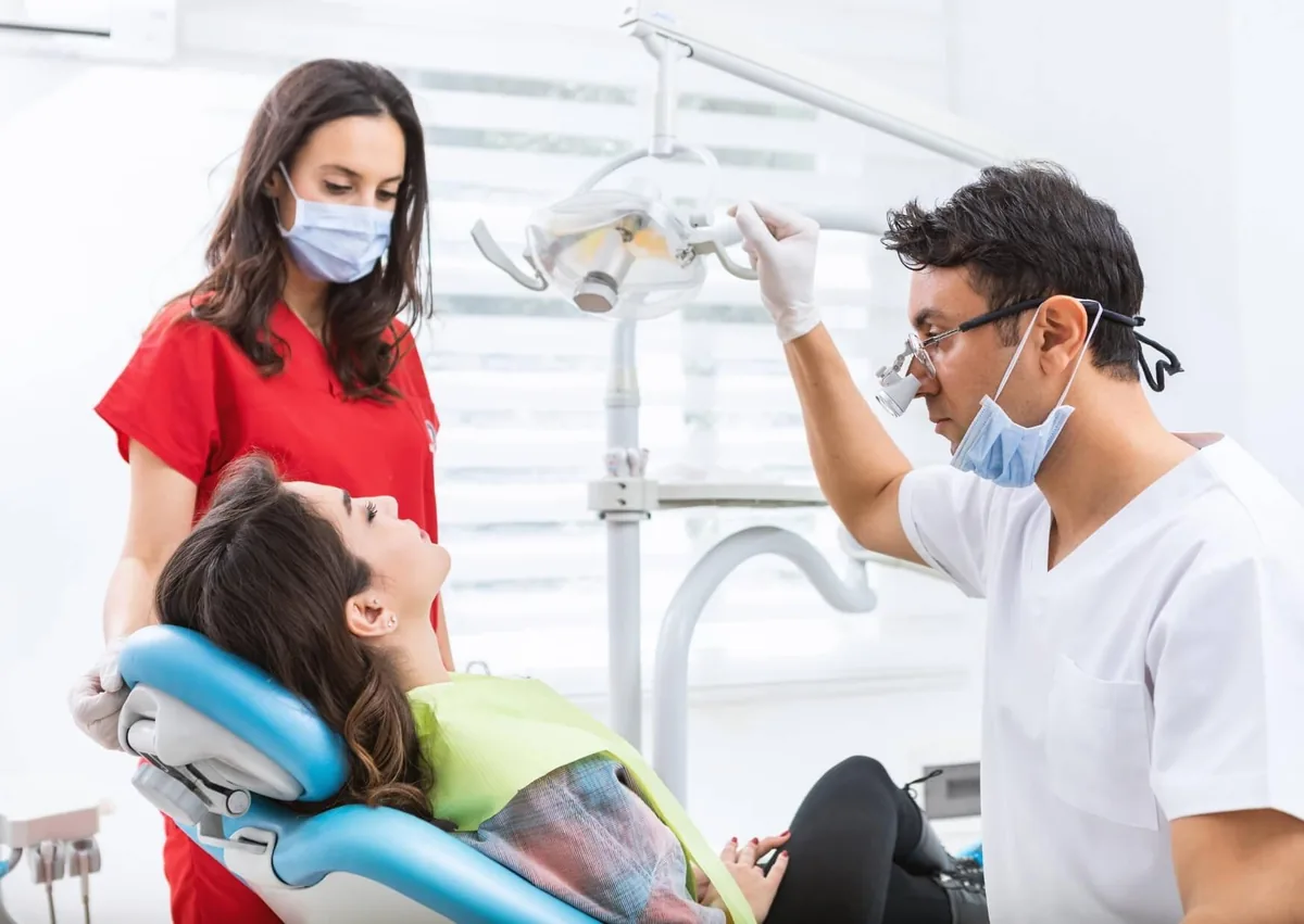 Dentist and dental assistant caring for a patient during a procedure with oral conscious sedation.