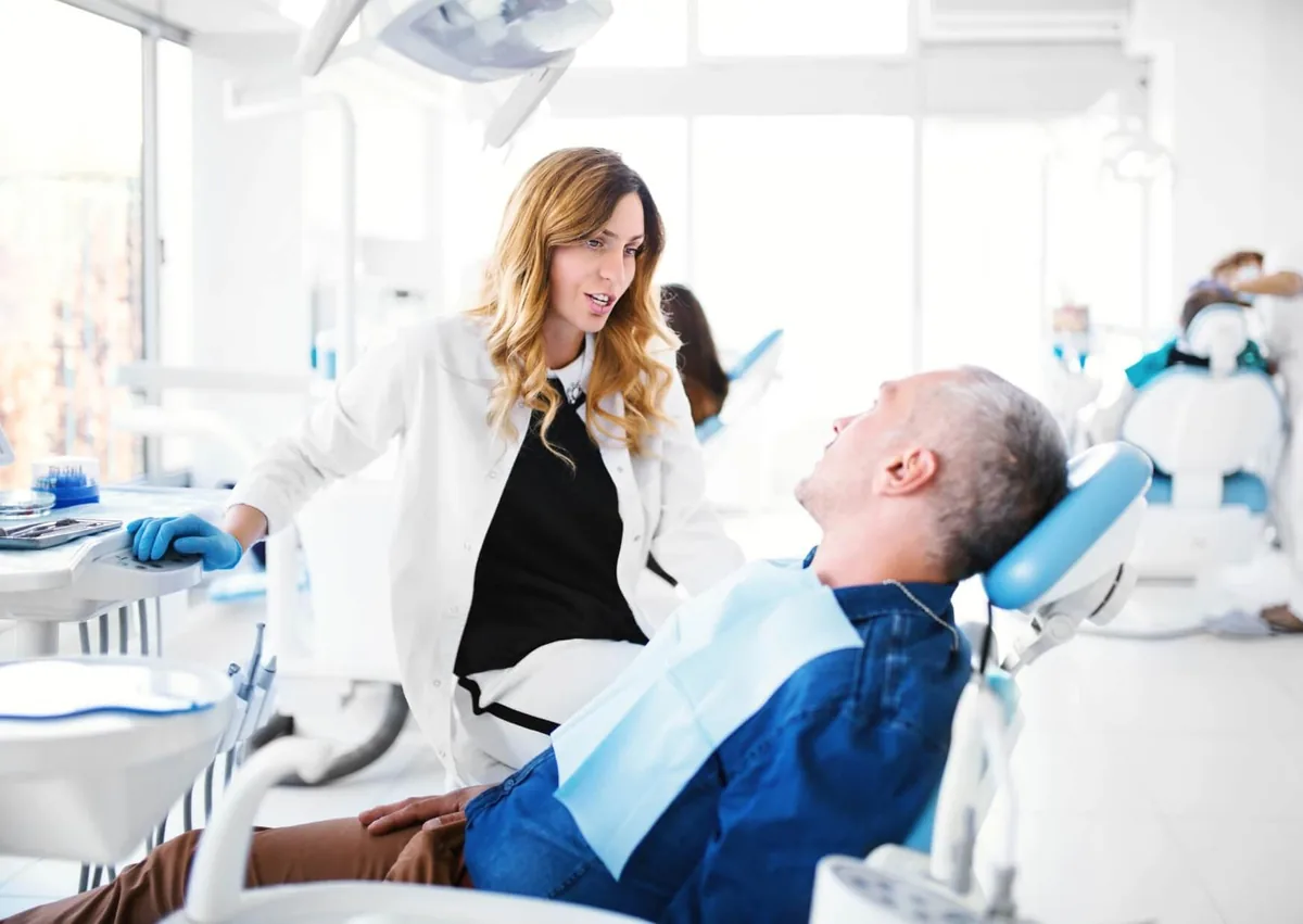 Dentist discussing a sleep apnea oral appliance with a patient during a dental consultation.